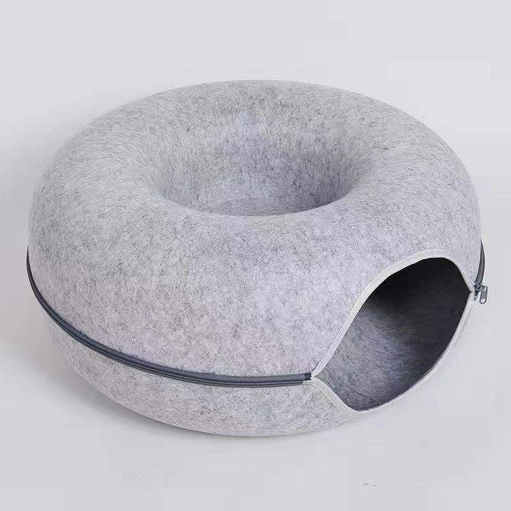 Light grey felt donut-shaped cat bed with a centre hole and a zippered side tunnel entrance.