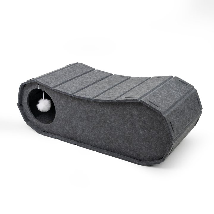 Dark grey felt sloped cat tunnel bed with a raised curved back and a hanging pompom toy.