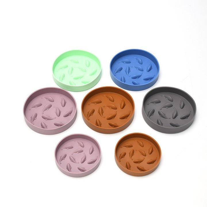 Round melamine pet bowls in several colours, each with a raised fish-shaped ridge pattern inside.