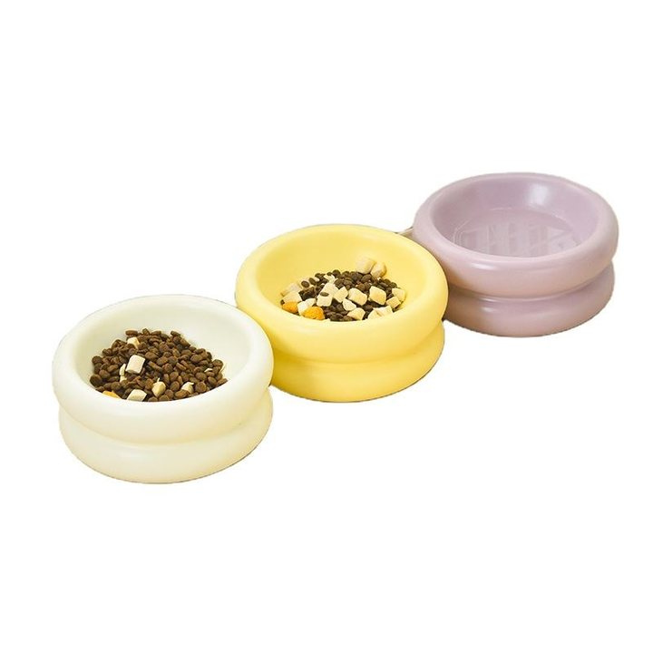 Small footed ceramic pet bowls in cream, pale yellow, and lavender