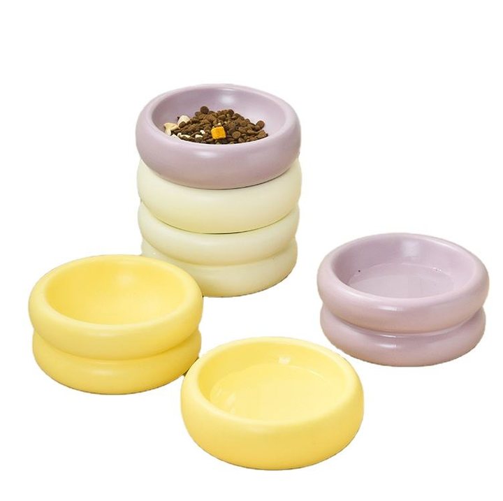 Small footed ceramic pet bowls in lavender, cream, and pale yellow