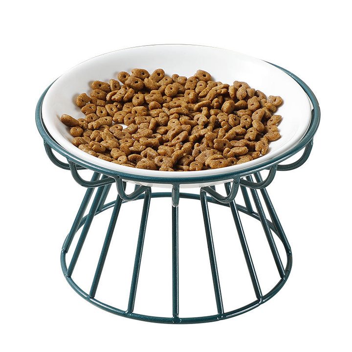 White ceramic pet bowl filled with kibble, set in a round dark-green wire frame stand.