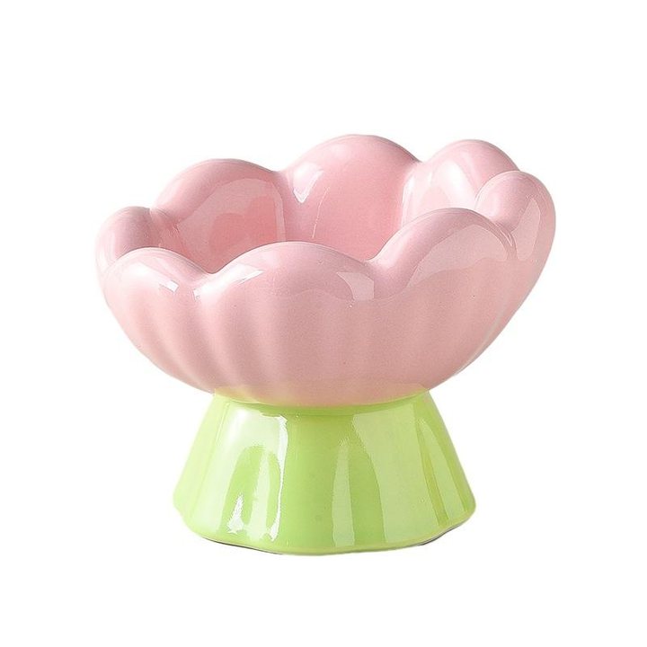 Pink flower-shaped ceramic pet bowl on a green pedestal foot.