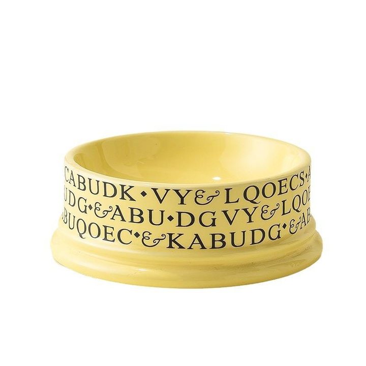 Yellow ceramic pet bowl with graffiti-style lettering printed around the outside.