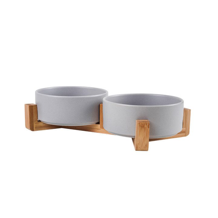 Two matte grey ceramic bowls joined together in a wooden stand.