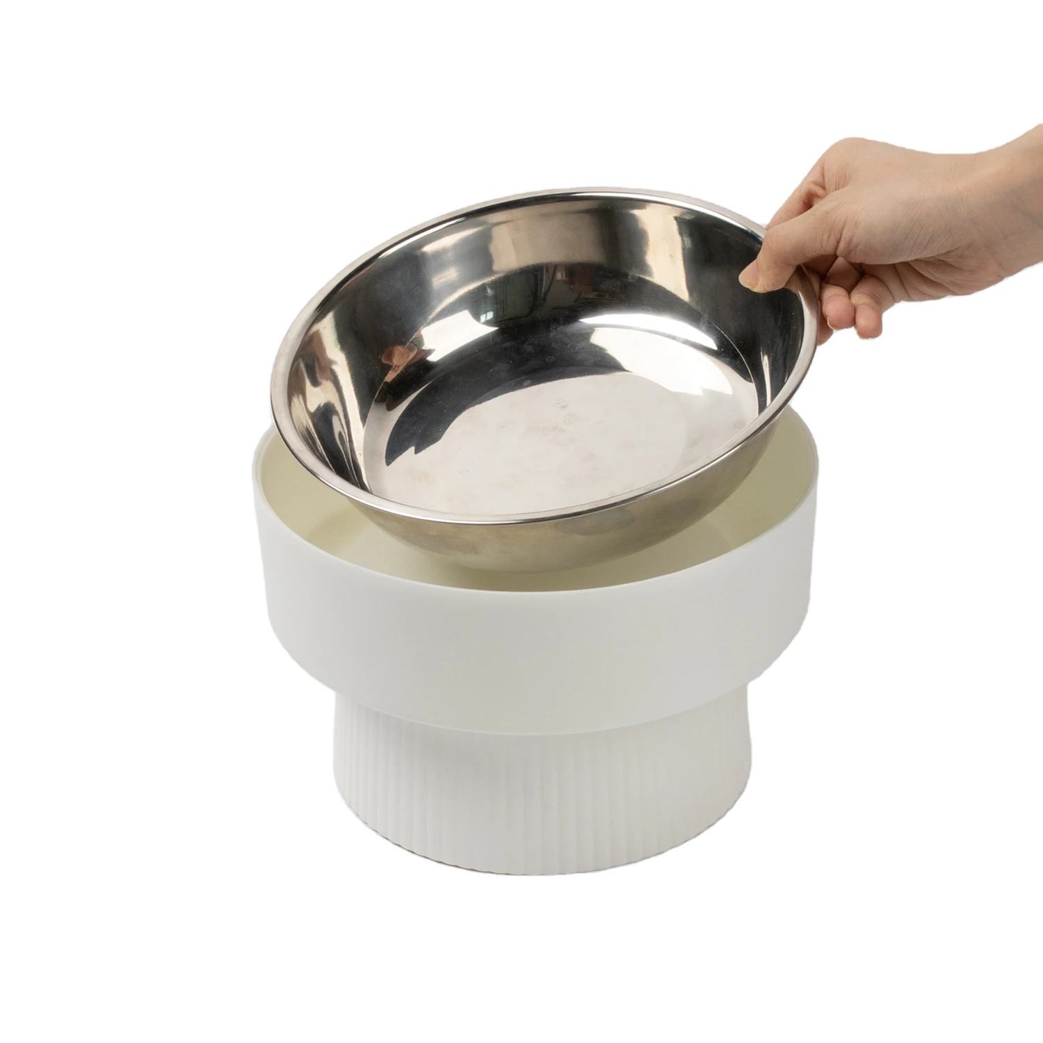 Cream raised feeder with its metal inner bowl being lifted out by a hand.