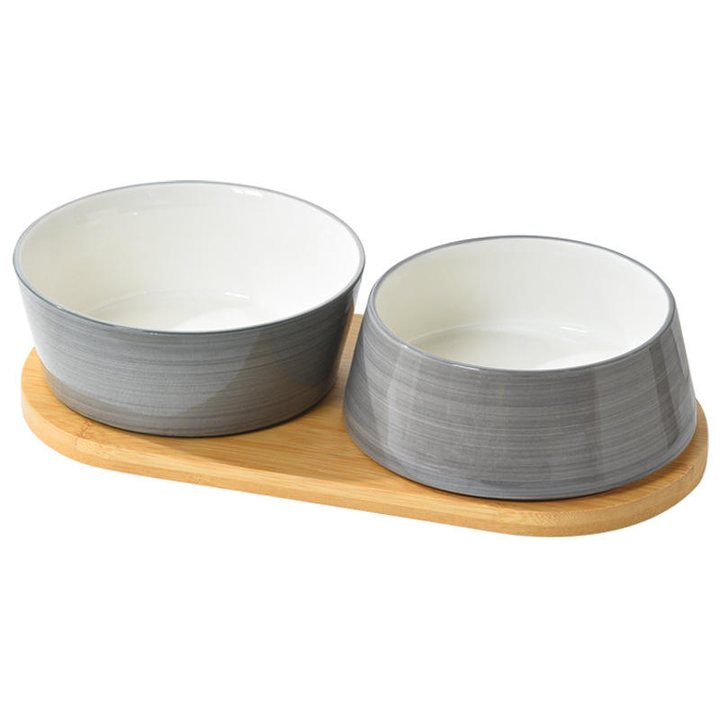 Two round ceramic bowls with grey exteriors, set on a light wood tray.