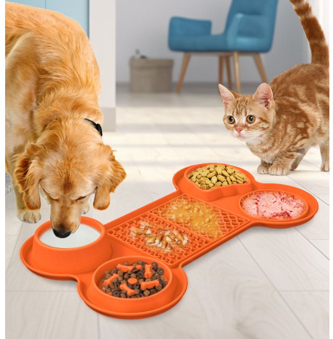 Orange bone-shaped silicone pet feeding mat with several built-in bowl and lick-mat compartments.