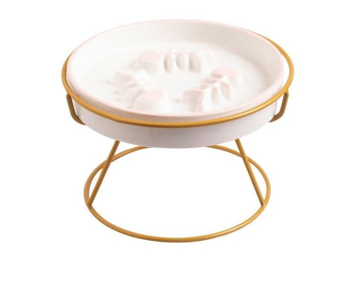 Round white raised pet feeding bowl with a paw-print-shaped divider ridge molded into the base, set in a gold-tone metal wire stand with a circular foot ring.
