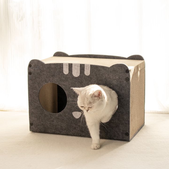 Grey felt cat-face-shaped house with round eye-hole openings and a corrugated cardboard scratch top.