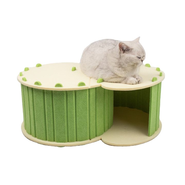 Green felt twin-chamber cat house with a cat resting on top and peeking into the open side.