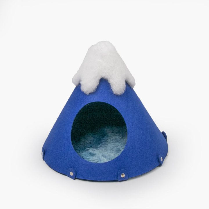 Cone-shaped felt cat cave styled as a mountain, with a plush white peak and a round entrance.