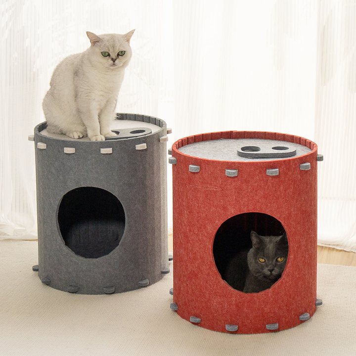 Two cylindrical felt cat houses, gray and red, each with a pull-tab lid, cats sitting on and inside them.
