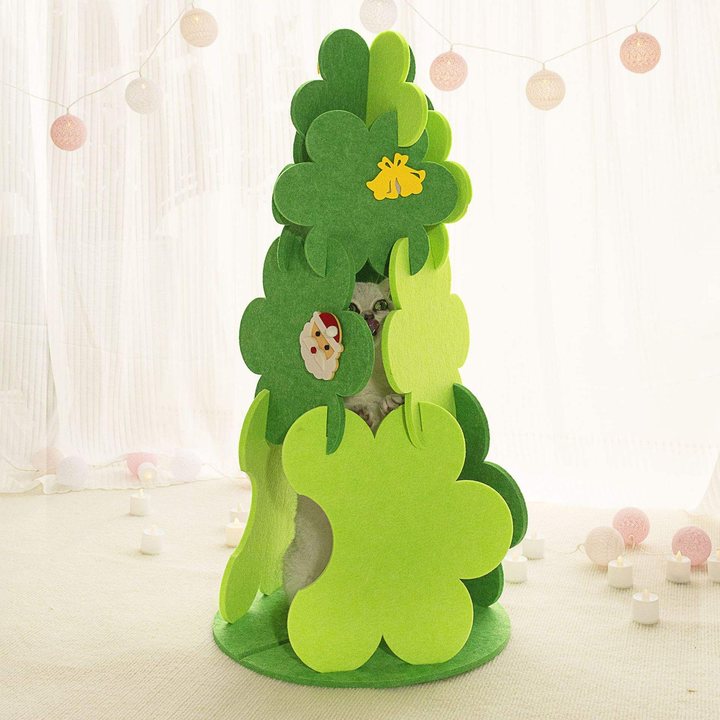 Felt cat house shaped like a layered Christmas tree with holiday appliques, a cat peeking out from inside.