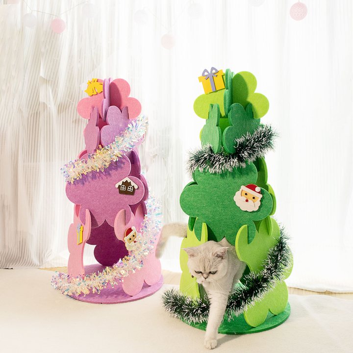 Two felt Christmas-tree-shaped cat houses, pink and green, decorated with tinsel and holiday appliques, cat walking out of one.