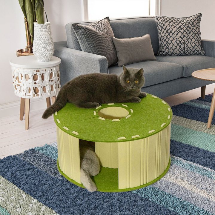 Round green felt cat house with ribbed sides in a living room setting