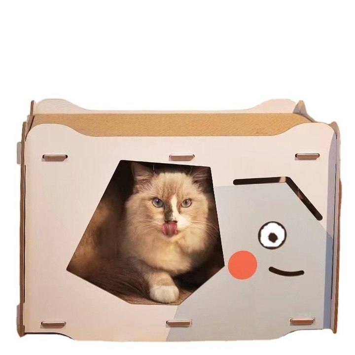 Cardboard cat house with a pentagon-shaped doorway and a cartoon-face print, cat resting inside the opening