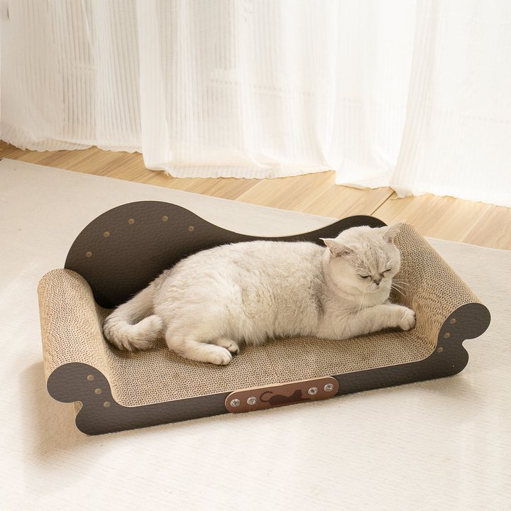 Dark brown faux-leather chaise-style cat scratcher lounge with scrolled arms and a natural cardboard scratch surface, shown in a home setting