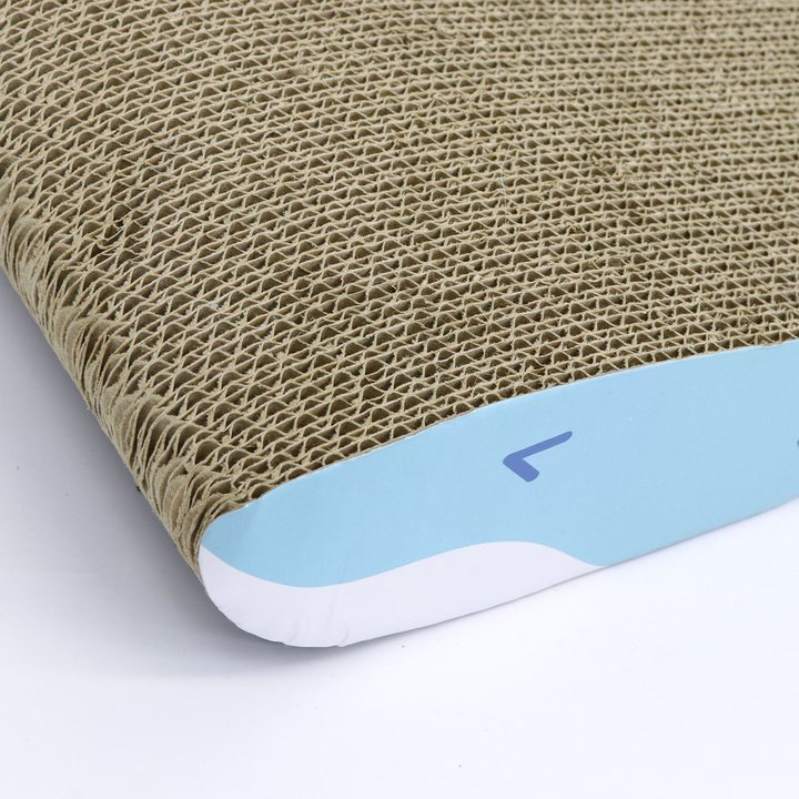 Close-up of corrugated cardboard scratch texture on a whale-shaped cat scratcher, showing the blue tail end panel
