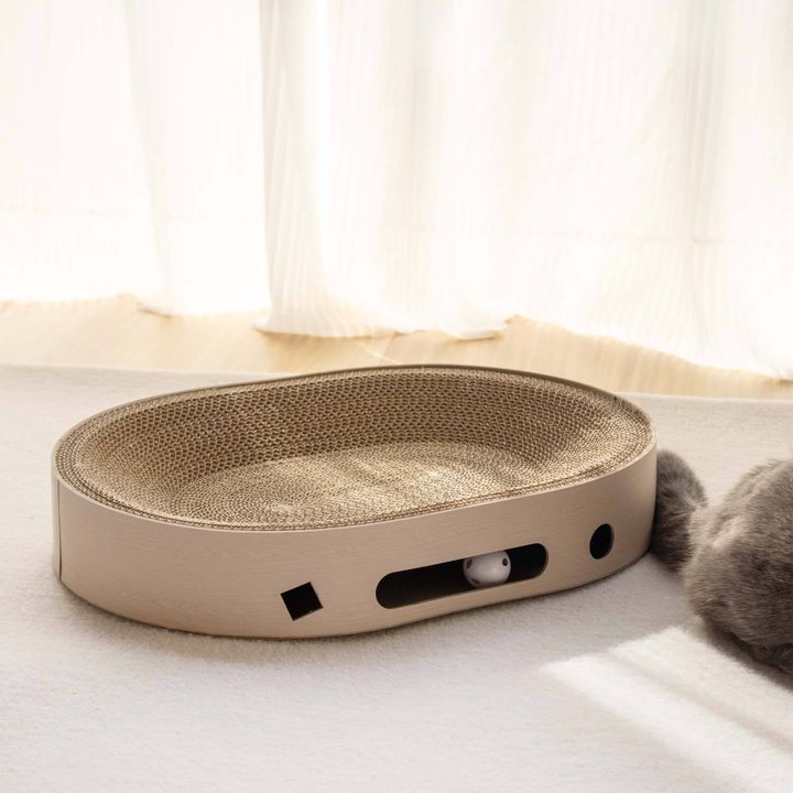 Oval cat scratcher lounge with a corrugated cardboard scratch surface and a built-in ball track.