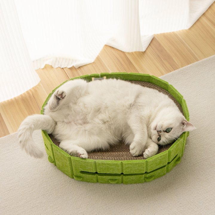 Oval cat scratcher nest with a green felt rim and corrugated cardboard base
