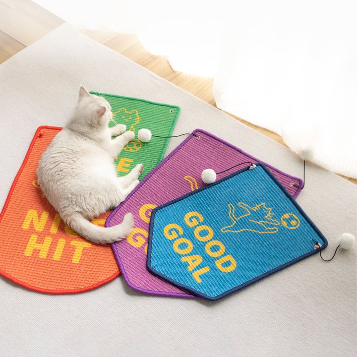 Flag-shaped woven sisal-style cat scratch mats in assorted colours with a hanging pom-pom toy