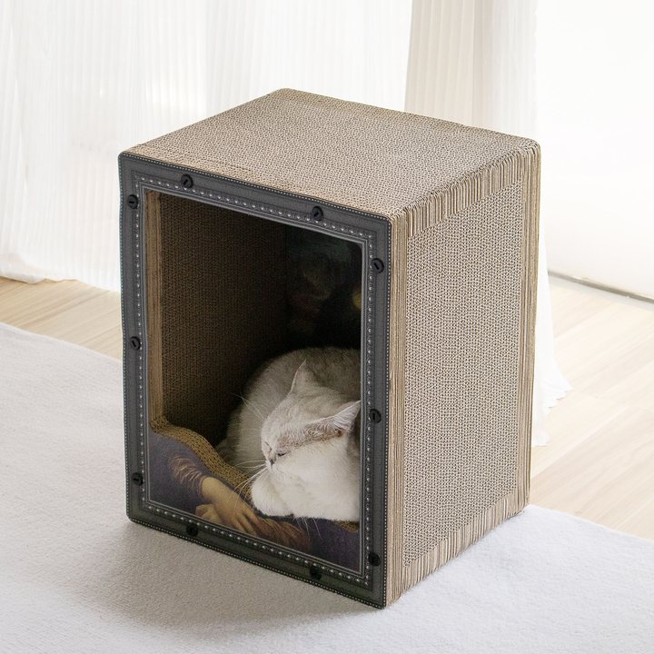 Cube-shaped corrugated cardboard cat scratcher box with a studded picture-frame front panel printed with a classical painting motif