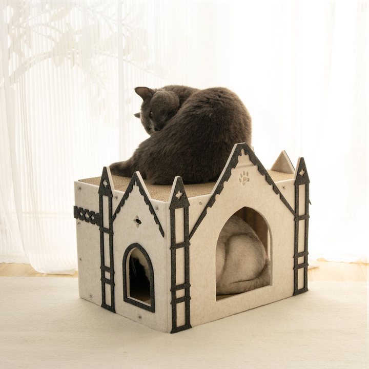 Cream and charcoal felt cathedral-style cat house with pointed gothic spires, an arched doorway and a corrugated cardboard scratch roof