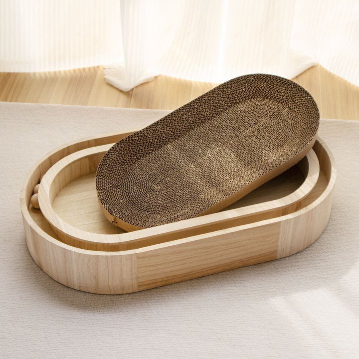 Oval wooden-framed cat scratcher box with a lift-out corrugated cardboard scratch pad, resting on a nested wooden ball-track tray.