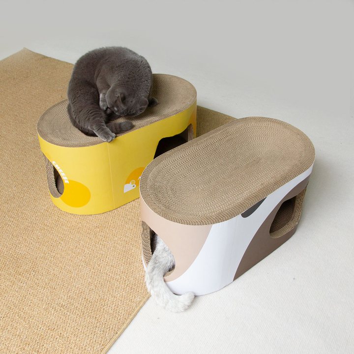 Two oval cat scratcher lounges with through-tunnels, one printed in a cheese-and-mouse theme and one in a white and brown two-tone finish.